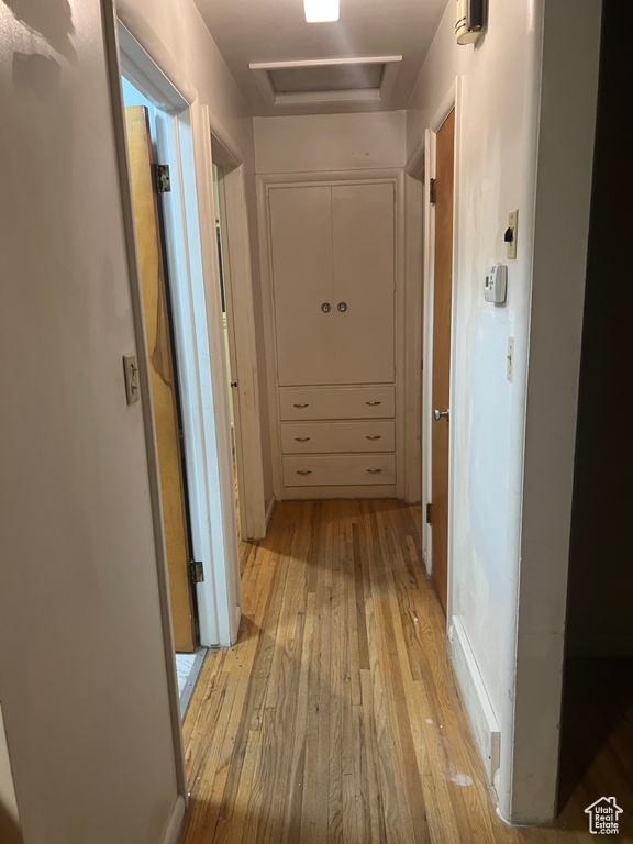 Hallway with light hardwood / wood-style flooring