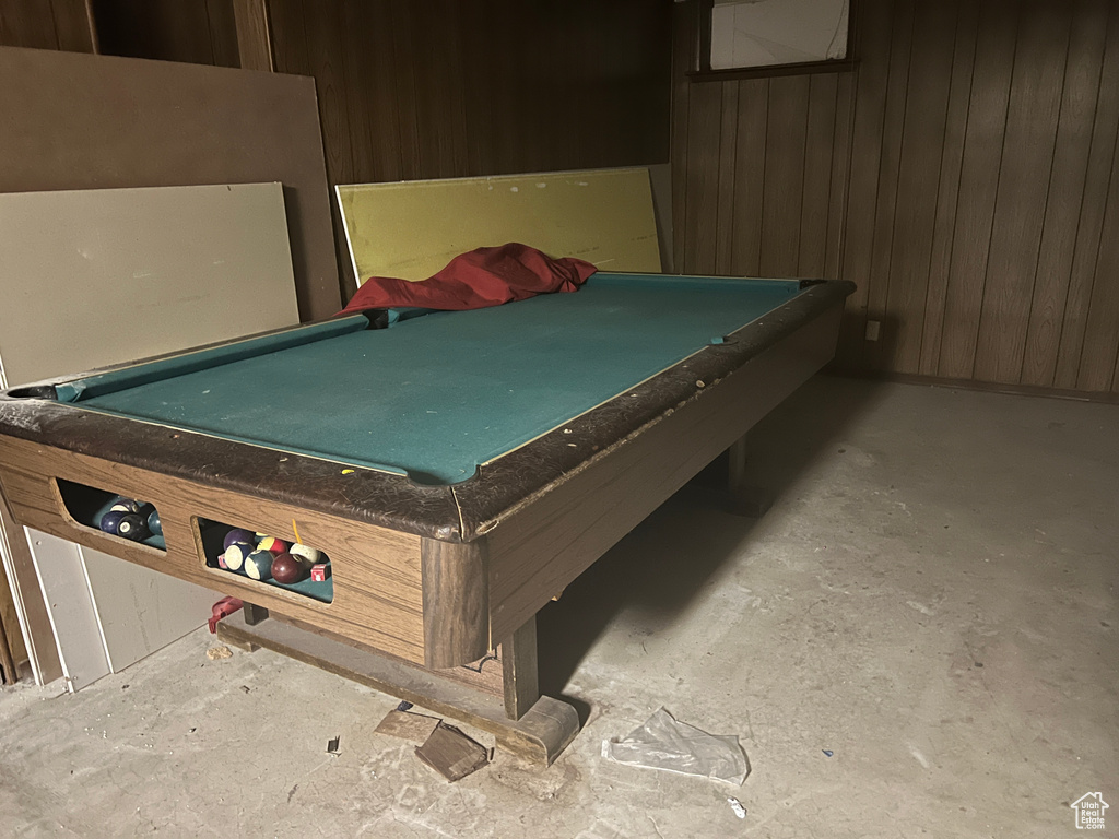 Playroom with wooden walls, billiards, and concrete floors