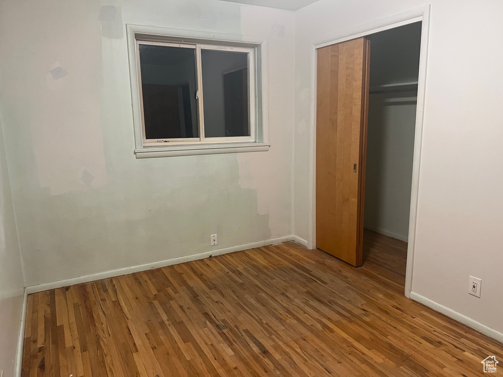 Unfurnished bedroom featuring hardwood / wood-style flooring and a closet