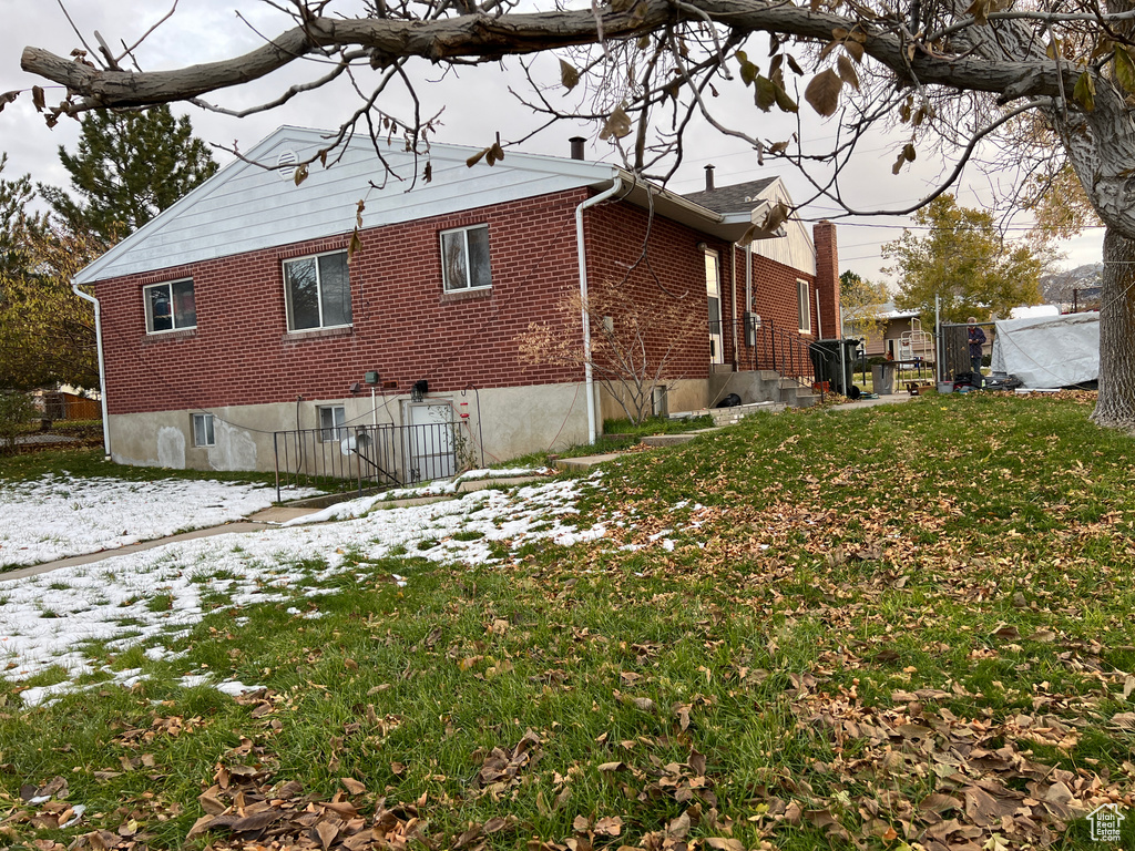 Snow covered property with a yard