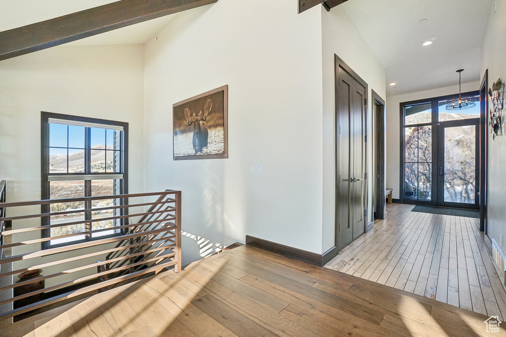 Foyer featuring wood-type flooring, french doors, recessed lighting, baseboards, and beam ceiling