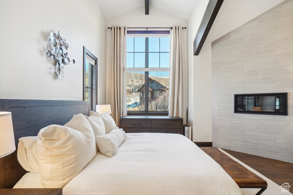Bedroom featuring wood finished floors, a fireplace, and baseboards