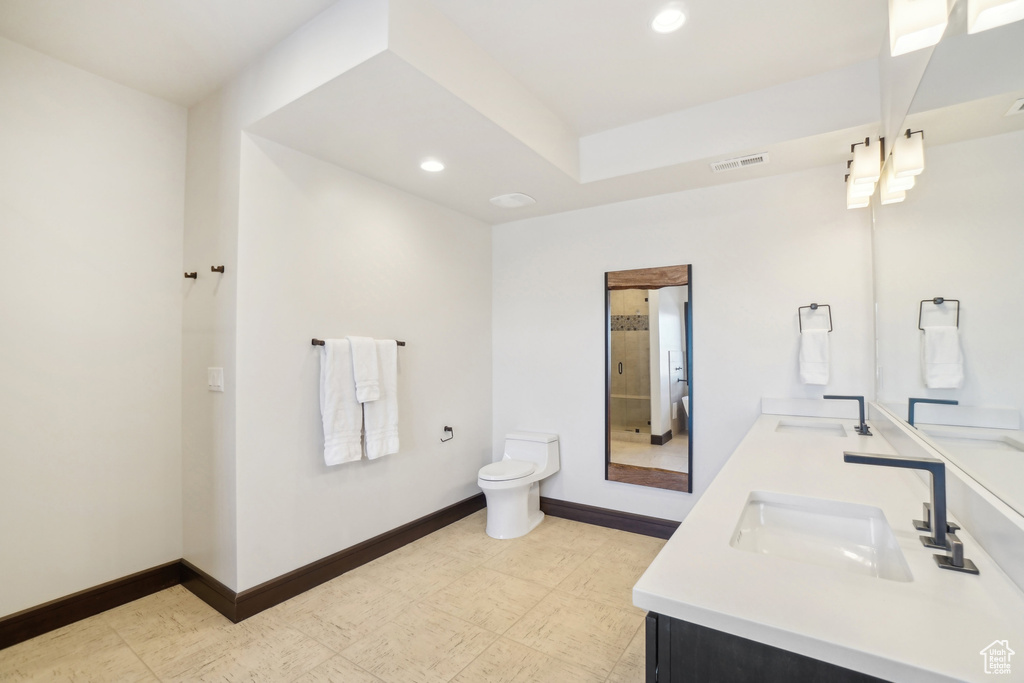 Bathroom with double vanity, recessed lighting, toilet, baseboards, and tile patterned floors