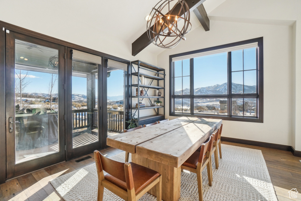 Dining area featuring a chandelier, hardwood / wood-style floors, a mountain view, and baseboards