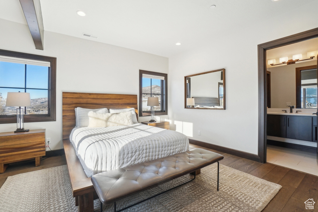 Bedroom featuring hardwood / wood-style floors, multiple windows, a sink, recessed lighting, and baseboards