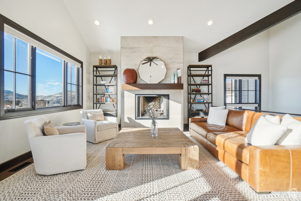 Living room featuring vaulted ceiling, a fireplace, recessed lighting, and plenty of natural light