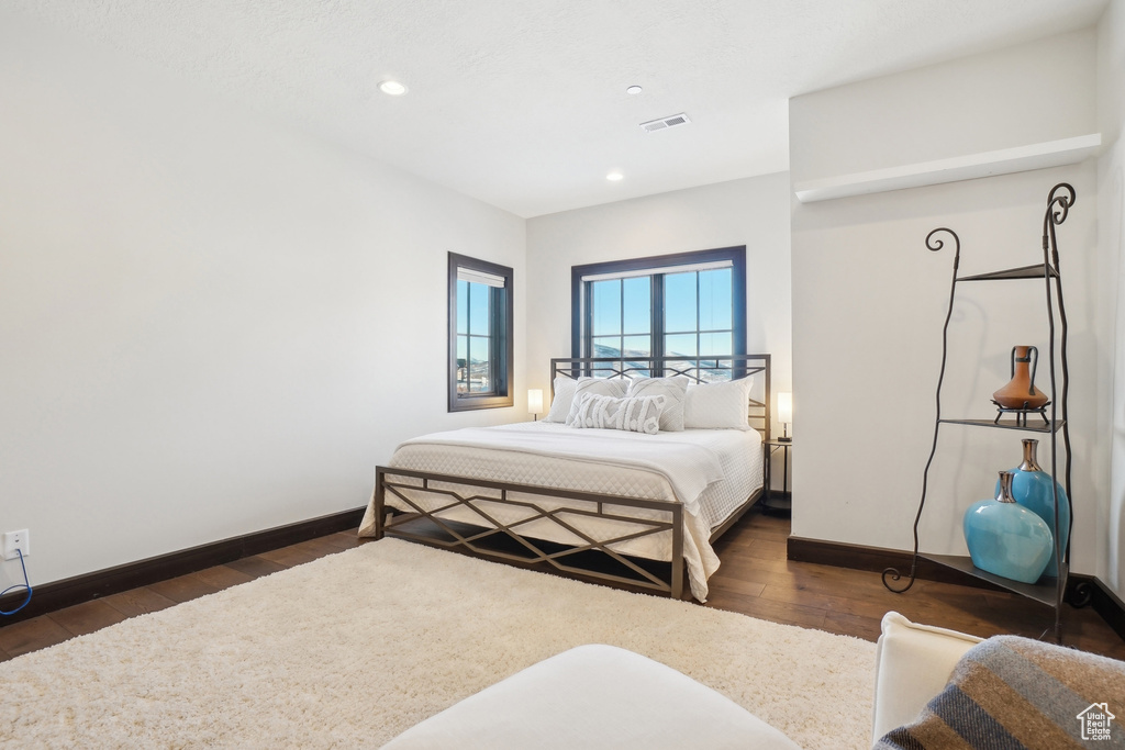 Bedroom with baseboards, dark wood-style floors, and recessed lighting