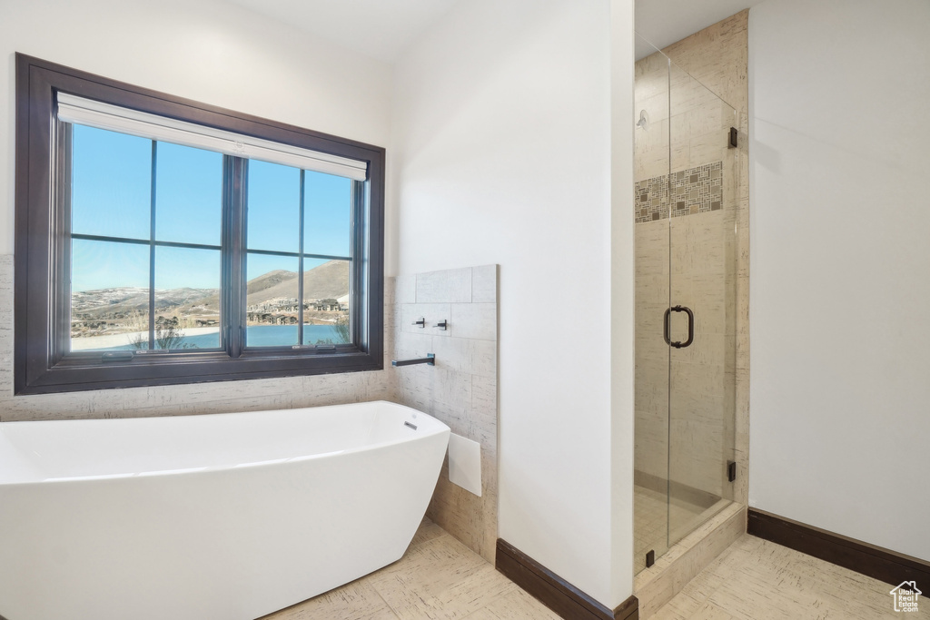 Full bath featuring a soaking tub and a stall shower