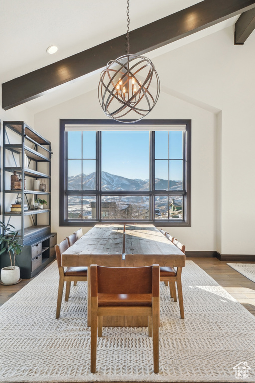 Dining space with a chandelier, wood finished floors, a mountain view, and baseboards