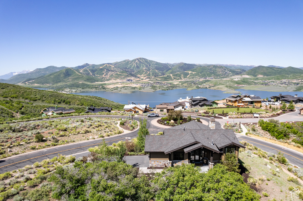Aerial view of property and surrounding area featuring a water and mountain view