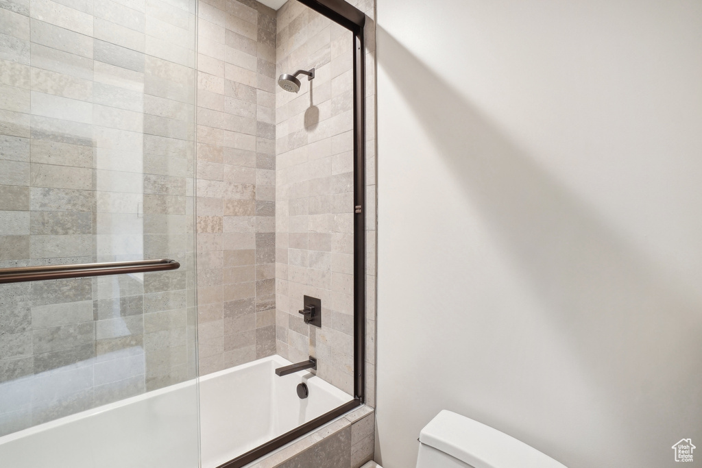 Full bath with toilet and combined bath / shower with glass door
