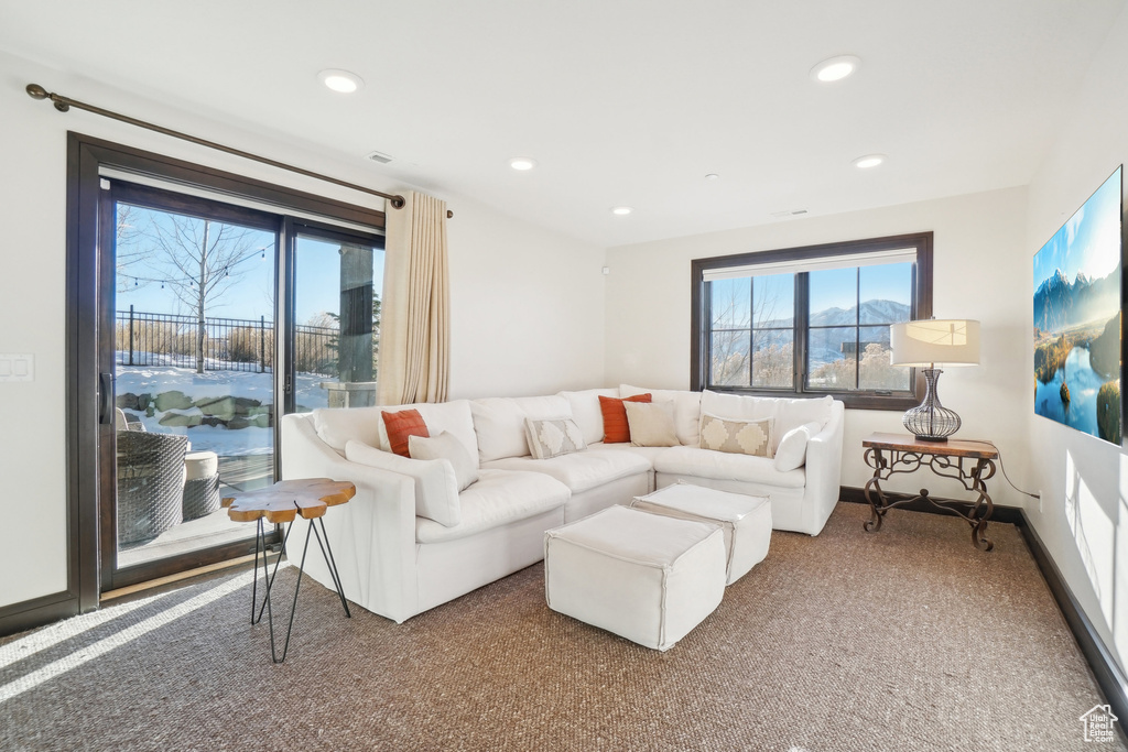 Carpeted living area featuring recessed lighting and baseboards