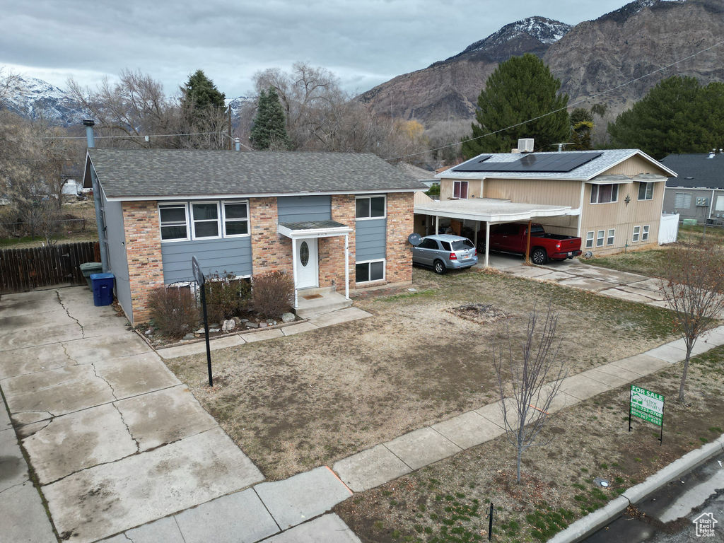 View of front of house with a mountain view and a carport