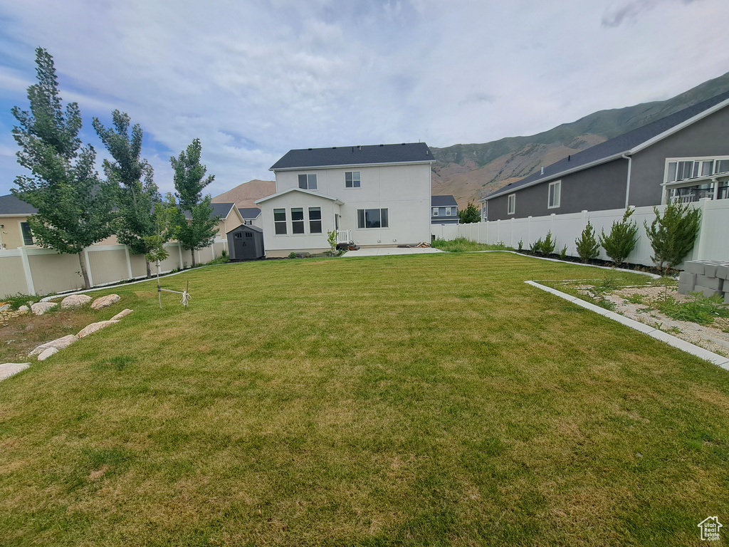 Rear view of property featuring stucco siding, a patio area, and a mountain view