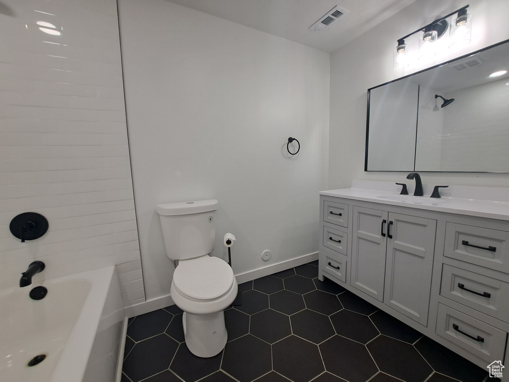 Full bathroom with toilet, vanity, baseboards, tile patterned floors, and shower / tub combination