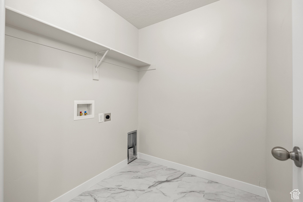 Laundry room featuring electric dryer hookup, hookup for a washing machine, and a textured ceiling