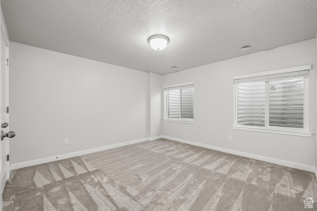 Carpeted spare room with a textured ceiling