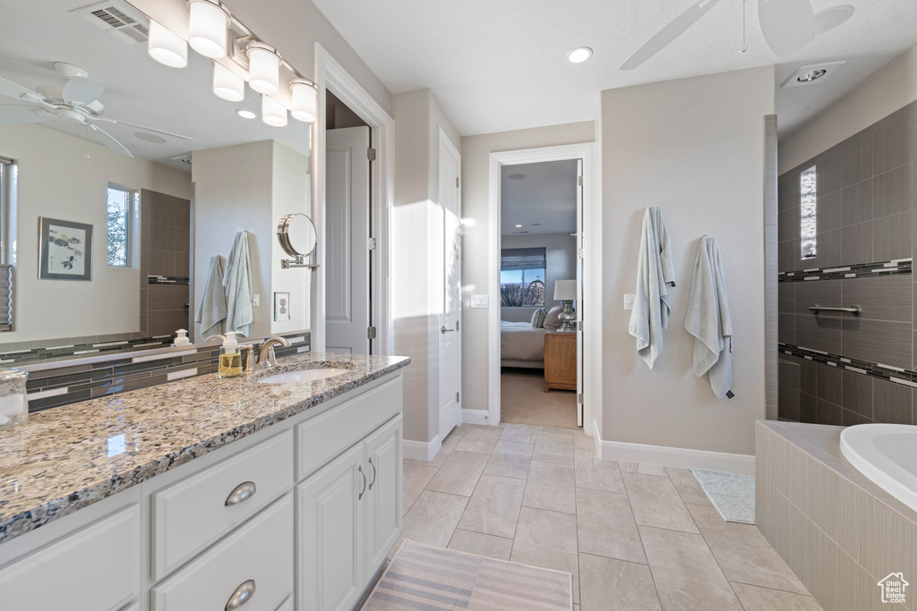 Bathroom featuring ceiling fan, vanity, and independent shower and bath
