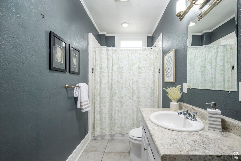 Bathroom with crown molding, vanity, tile patterned floors, toilet, and walk in shower