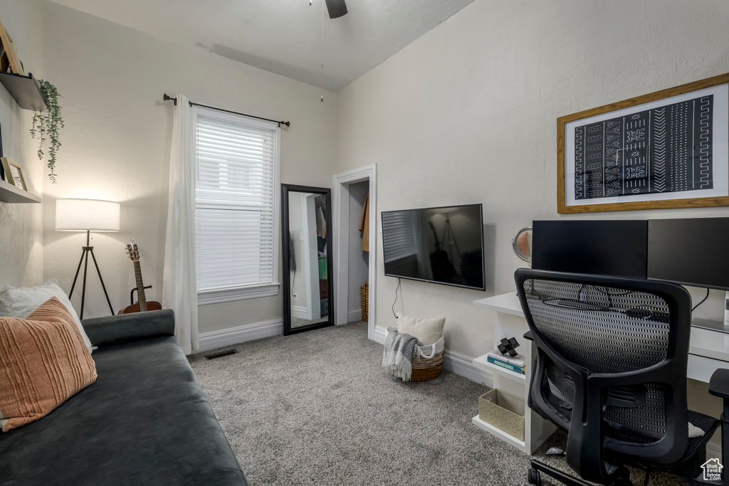 Carpeted office space featuring lofted ceiling and ceiling fan