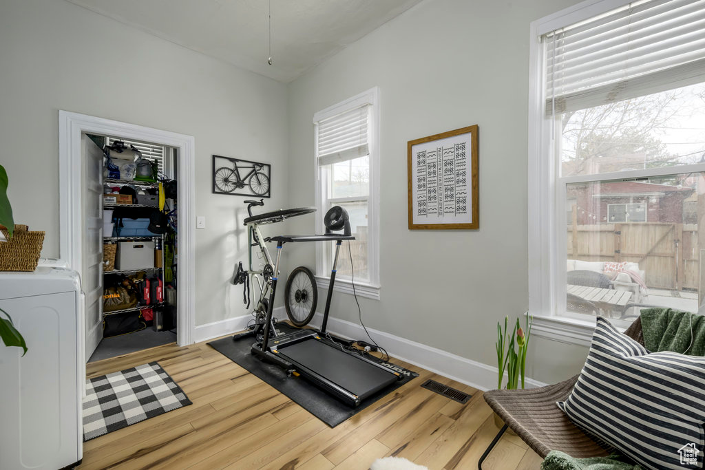 Workout room featuring washer / clothes dryer and hardwood / wood-style floors