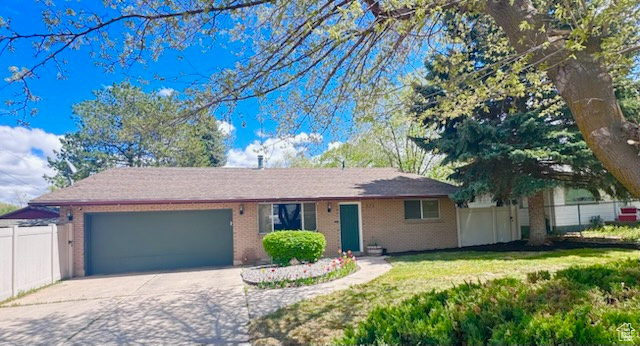 Single story home with fence, an attached garage, driveway, and brick siding