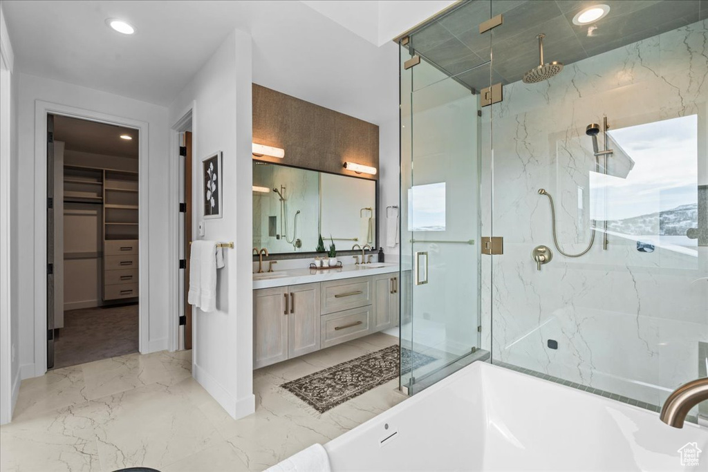 Bathroom featuring shower with separate bathtub and vanity