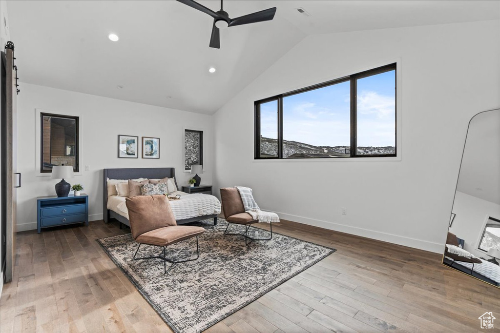 Bedroom with hardwood / wood-style floors, vaulted ceiling, and ceiling fan