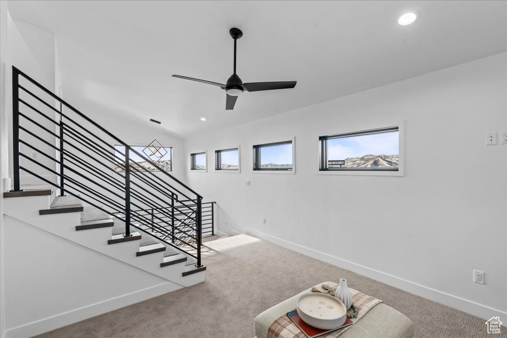 Staircase with carpet flooring and ceiling fan