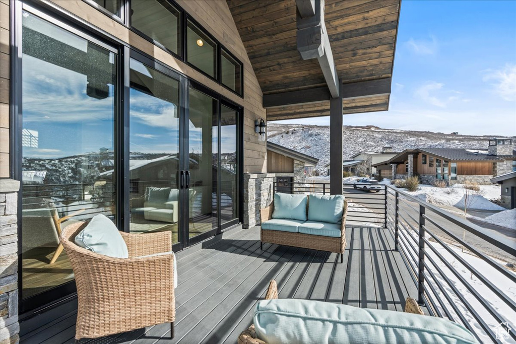 Snow covered back of property featuring an outdoor living space