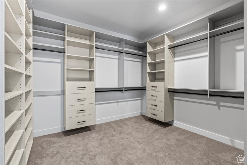 Walk in closet featuring light colored carpet