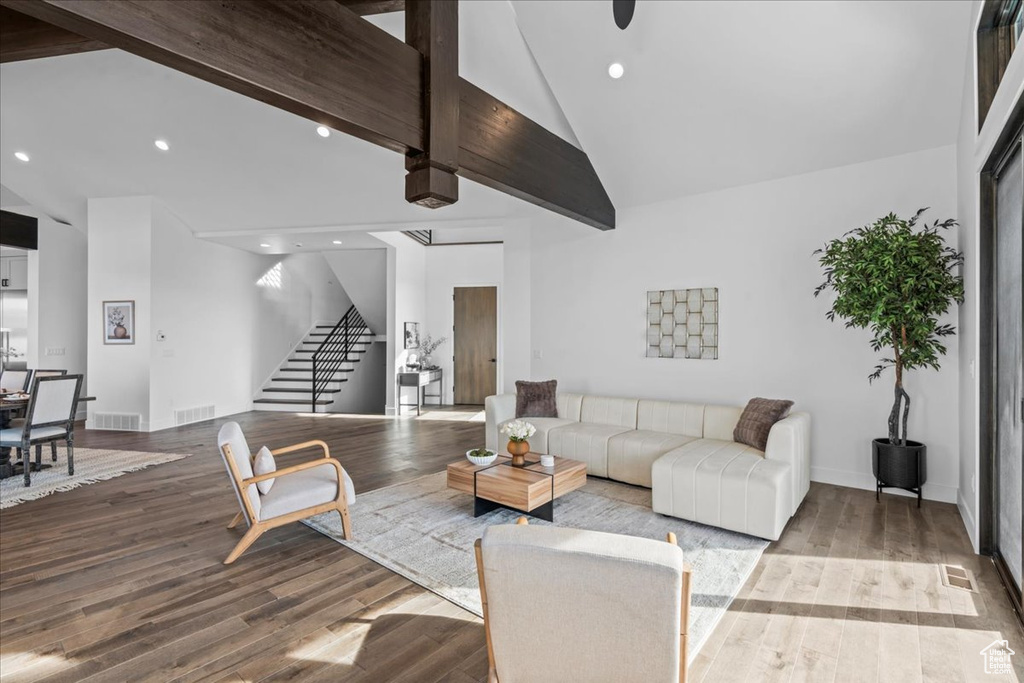 Living room featuring beamed ceiling, high vaulted ceiling, and light hardwood / wood-style flooring