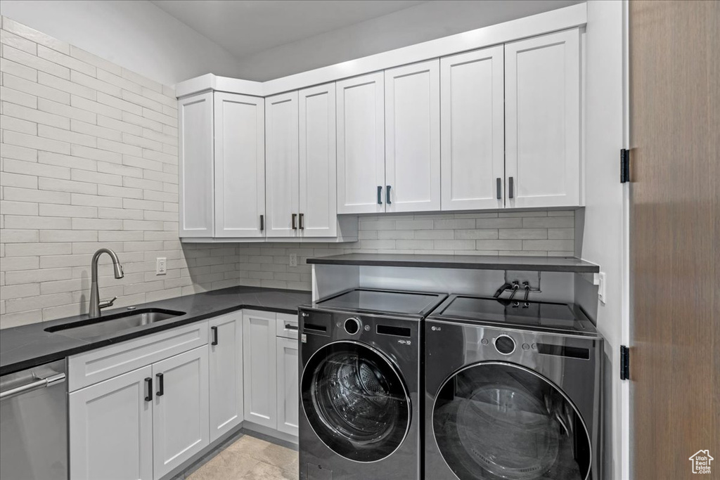 Laundry area with washing machine and clothes dryer and sink