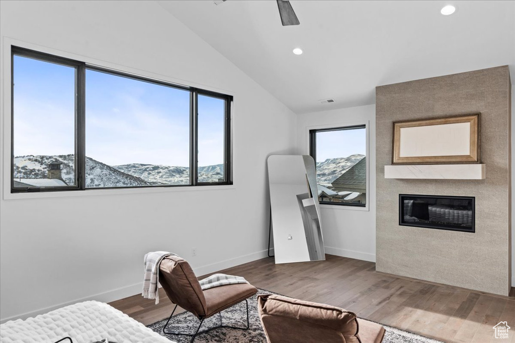 Bedroom featuring lofted ceiling, a mountain view, and multiple windows