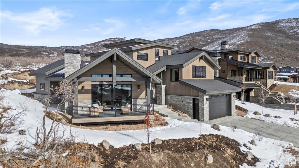 View of front of house featuring a porch, a garage, and a mountain view