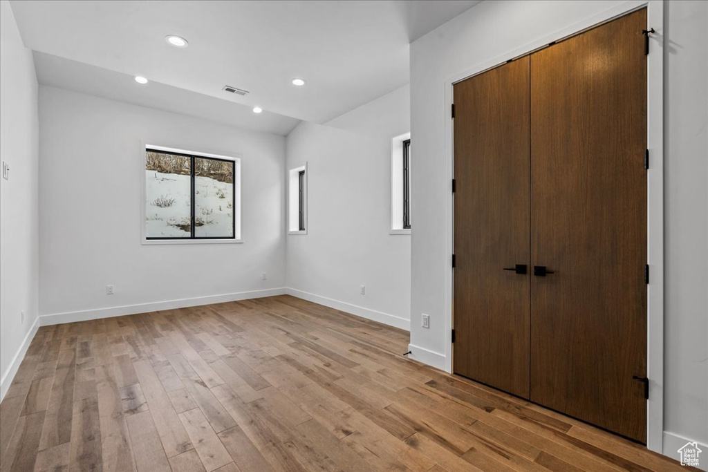 Unfurnished bedroom with light hardwood / wood-style flooring and a closet