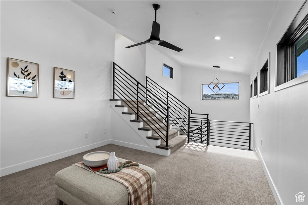 Living area with ceiling fan, high vaulted ceiling, and carpet floors