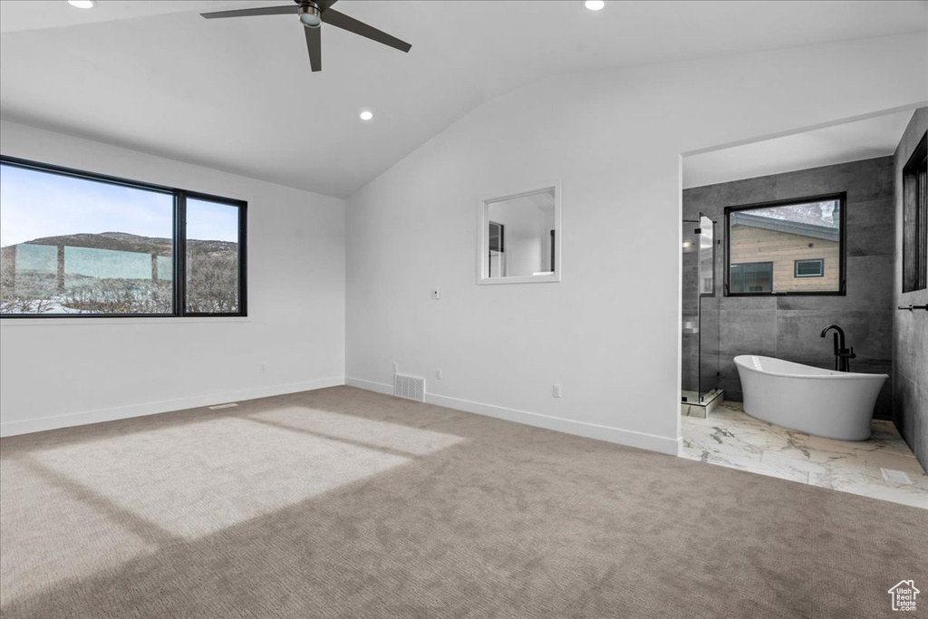 Unfurnished bedroom featuring ceiling fan, vaulted ceiling, and light carpet