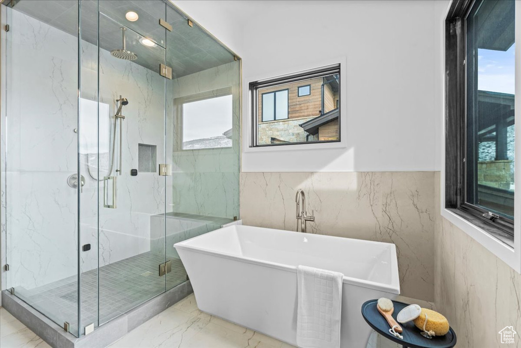 Bathroom with tile walls and plus walk in shower