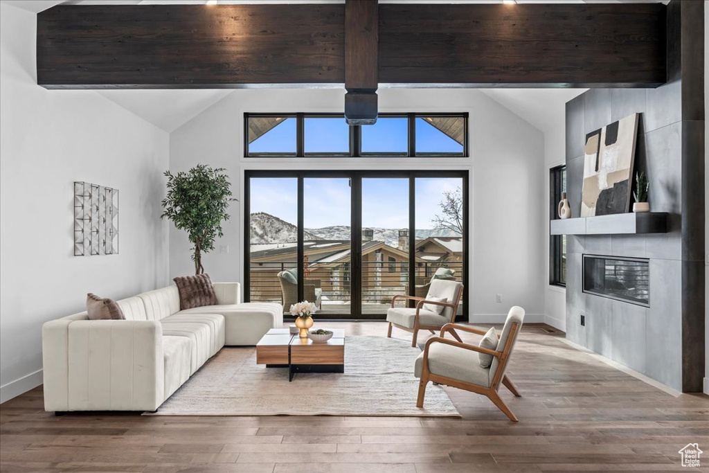 Living room with lofted ceiling with beams, a fireplace, a mountain view, and hardwood / wood-style floors