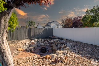 Yard at dusk featuring a fire pit and a fenced backyard
