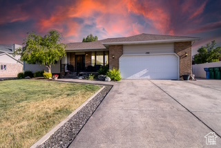 Single story home with an attached garage, concrete driveway, and a lawn