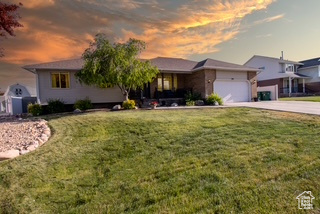 View of front of home featuring a garage, a front lawn, and driveway