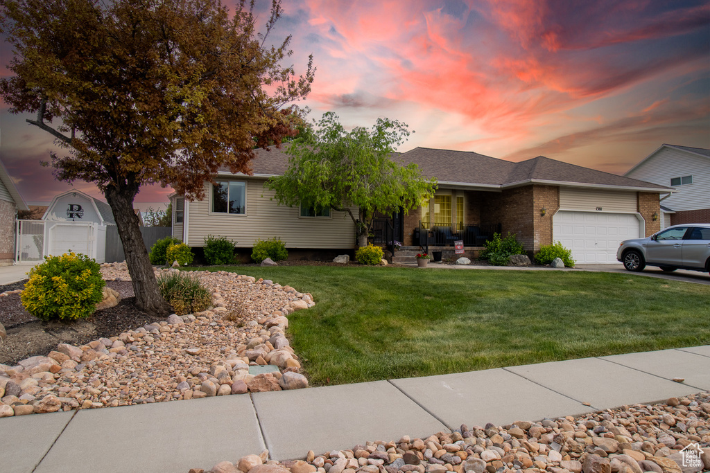 Ranch-style house with a front lawn, a garage, roof with shingles, brick siding, and driveway