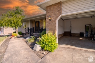View of exterior entry featuring driveway, a porch, and stone siding