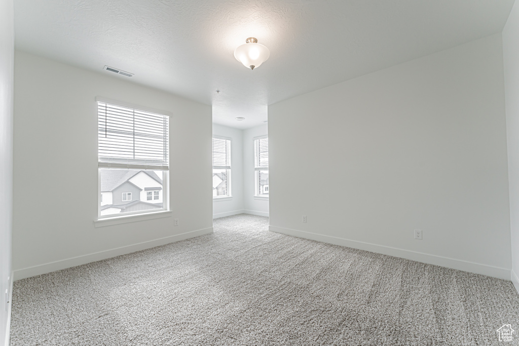 Carpeted spare room with baseboards