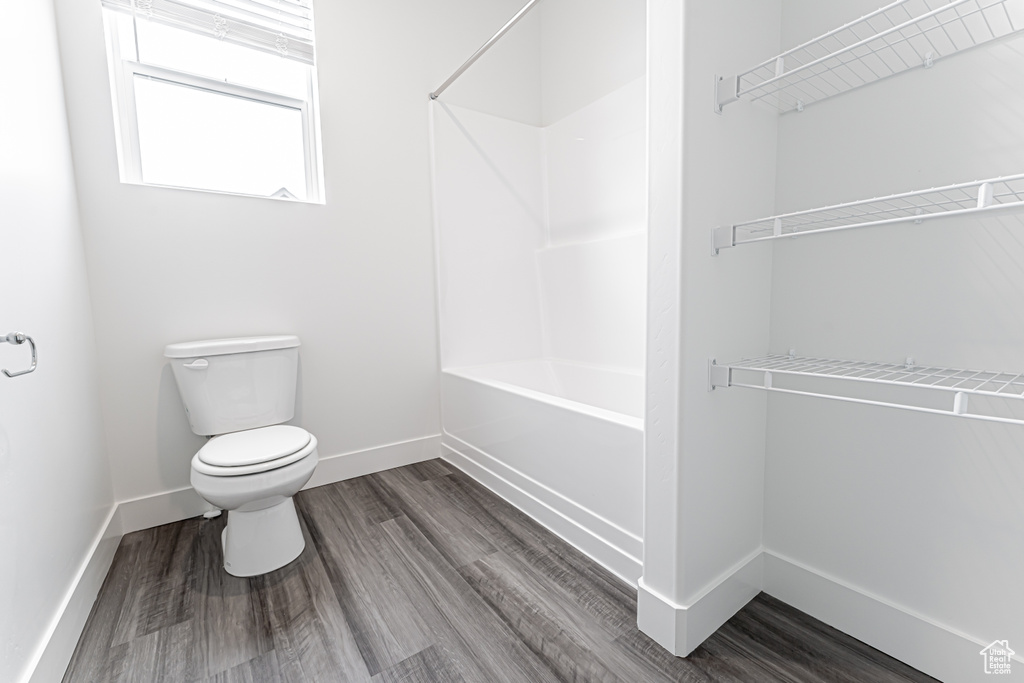 Full bath featuring tub / shower combination and wood finished floors