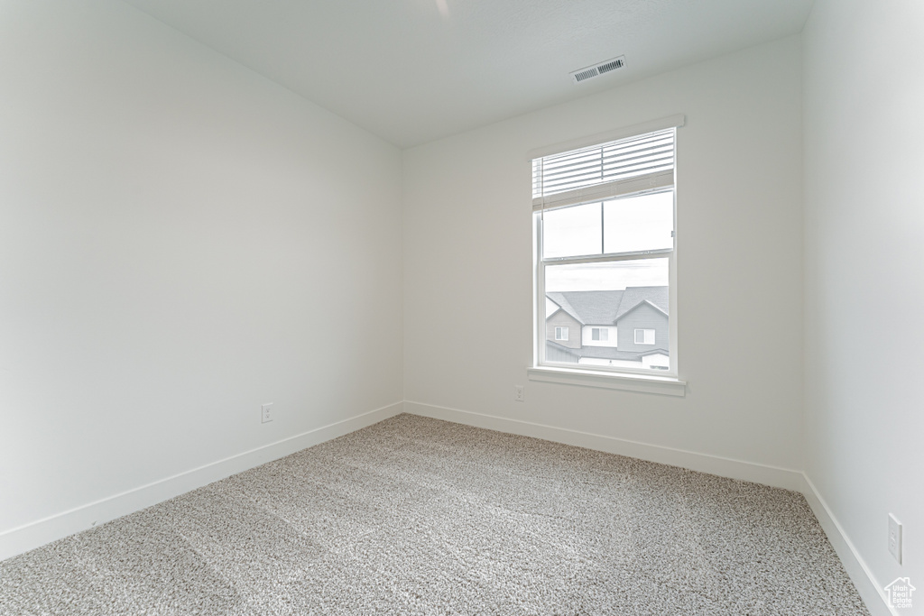 Spare room with light carpet and baseboards