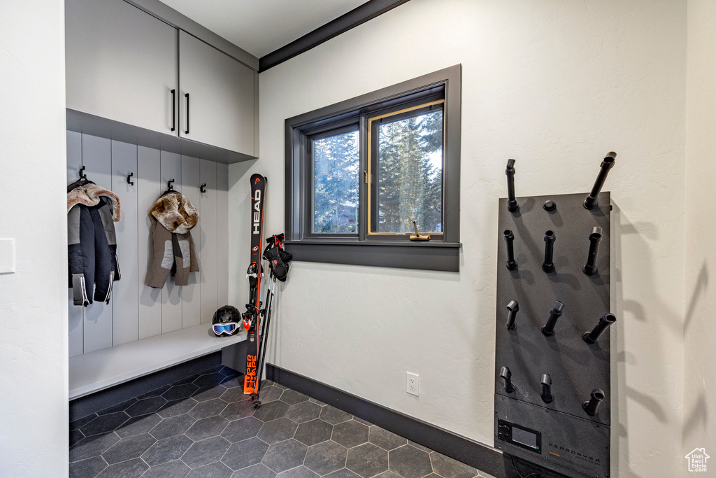 Mudroom with dark tile patterned flooring and baseboards