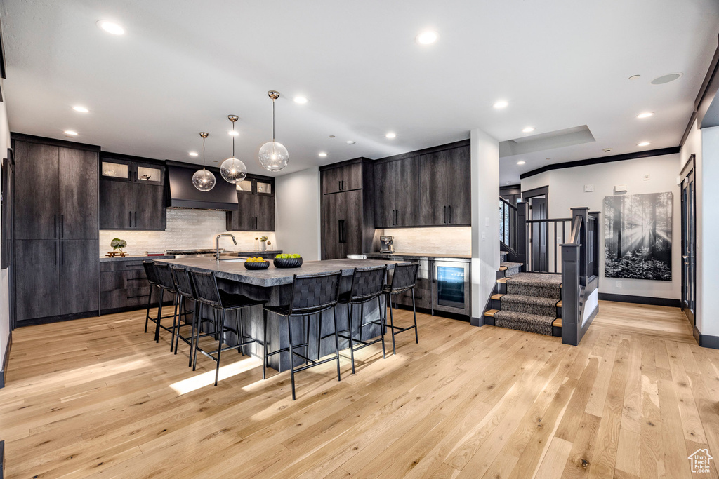 Kitchen featuring a kitchen breakfast bar, decorative backsplash, dark brown cabinetry, and recessed lighting